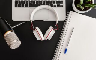 podcast, notebook, laptop, headphones for content marketing on a dark table
